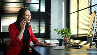 有吸引力的高加索人女商人细胞电话谈话工作电脑现代办公室