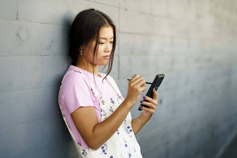 中国人女孩智能<strong>手机</strong>笔<strong>手写</strong>笔在户外