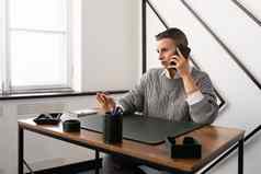 成熟的业务女人会说话的移动电话坐着工作场所办公室