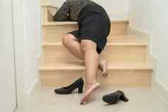 亚洲业务女人穿高高跟鞋疼痛脚踝脚腿抽筋秋天楼梯湿滑的表面办公室