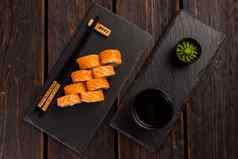 寿司卷费城大马哈鱼黄瓜奶油奶酪黑色的背景寿司菜单日本食物概念前视图