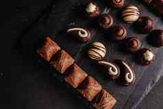 巧克力糖果黑暗背景前视图很多巧克力分类美味的巧克力