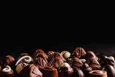 巧克力糖果黑暗背景前视图很多巧克力分类美味的巧克力