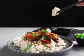 亚洲厨房女人的手持有亚洲食物棒大米鸡灰色的背景视图煮熟的大米炒切片鸡乳房罗勒泰国厨房