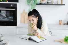 健康的吃年轻的女人吃很多绿色自我保健女人阅读杂志饮食健康的吃