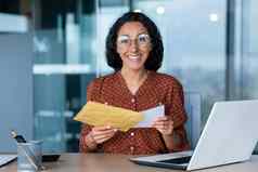 快乐拉美裔女人微笑相机业务女人收到了信封好新闻通知信办公室工人文档移动PC工作办公室工作