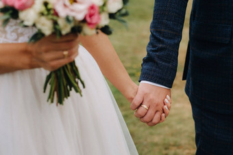 新娘的婚礼花束新鲜的粉红色的花手持有手新郎婚礼细节