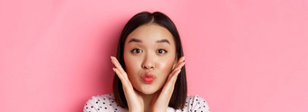 美生活方式概念特写镜头可爱的亚洲女人触碰脸皱纹嘴唇吻站粉红色的背景