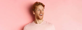 特写镜头英俊的高加索人的家伙红色的头发胡子左快乐微笑检查促销提供站粉红色的背景