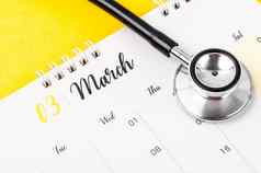 听诊器医疗3月桌子上日历红色的背景时间表检查健康的概念