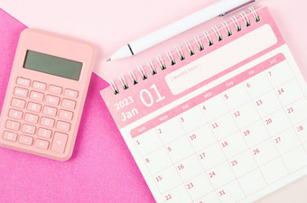 1月桌子上日历一年计算器笔粉红色的颜色背景
