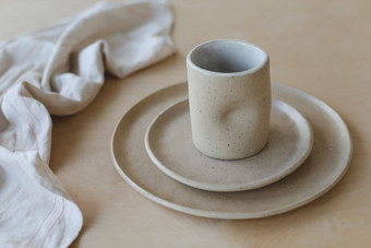 <strong>陶瓷</strong>板木表格前视图极简主义手工制作的<strong>陶瓷餐具</strong>陶器