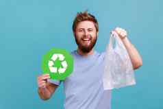 男人。t恤持有绿色回收标志塑料袋相机愉快的微笑