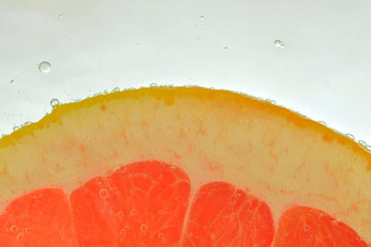 特写镜头新鲜的葡萄柚片白色背景片红色的葡萄柚闪闪发光的水白色背景特写镜头水平图像