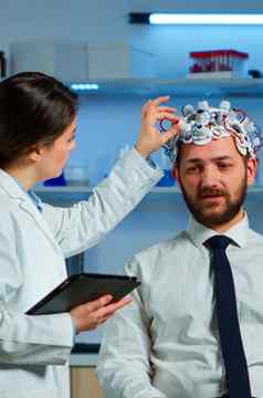 病人穿脑电波扫描耳机讨论神经系统研究员