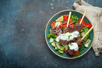 烤串肉扦肉牛肉烤肉串棒服务新鲜的蔬菜沙拉板乡村混凝土背景传统的中间东部土耳其菜烤肉串空间文本