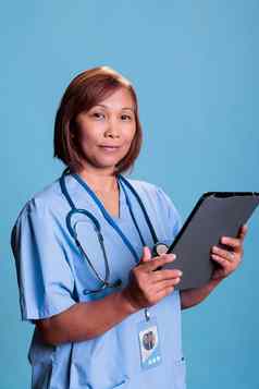 上了年纪的护士持有数字设备检查医疗保险