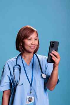 快乐的护士持有智能手机会说话的远程医生在线videocall