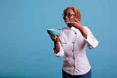女非洲美国烹饪显示光蓝色的碗