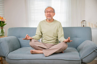 亚洲男人。练习瑜伽冥想莲花位置关闭眼睛