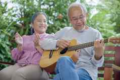 高级夫妇上了年纪的男人。玩吉他妻子唱歌