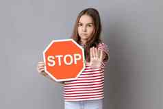女孩覆盖脸八角形的停止象征显示交通标志禁止手势棕榈