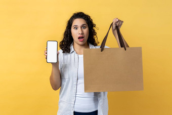 女人持有纸购物袋移动电话空屏幕复制空间促销活动