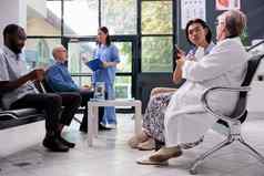 上了年纪的专家医生坐着椅子医院等待房间持有止痛药瓶