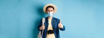 科维德夏天假期概念微笑的家伙旅行医疗面具稻草他徒步旅行显示拇指批准赞美旅行机构蓝色的背景