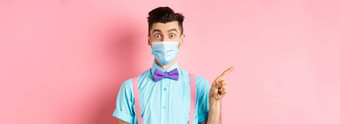科维德流感大流行健康概念图像惊讶的家伙医疗面具促销交易指出手指左好奇的站粉红色的背景