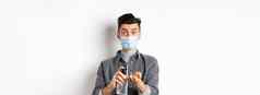健康科维德流感大流行概念现代的家伙脸面具清洁手防腐剂洗手液瓶站白色背景