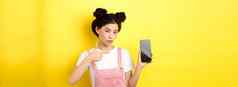 在线购物概念时尚的亚洲女人粉红色的化妆指出空智能手机斯雷恩显示好交易黄色的背景