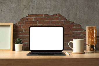 前面视图数字平板电脑无线键盘咖啡杯书图片框架木工作桌子上