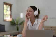 年轻的女人听音乐在线穿无线耳机享受最喜欢的首歌播放列表音乐应用程序