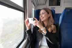 美丽的女孩需要图片景观智能手机坐着火车