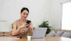 亚洲女人移动电话检查电子邮件社会媒体互联网会计金融概念