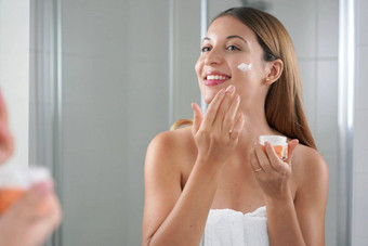 护肤品女人应用奶油脸颊脸保湿滋养精力充沛的治疗享受放松时间