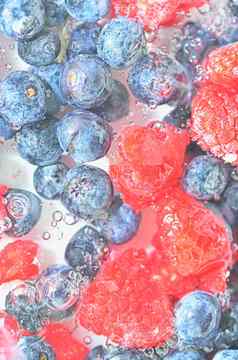 蓝莓树莓液体泡沫色彩鲜艳的成熟的越桔树莓水特写镜头新鲜的浆果水背景前视图平设计垂直宏图像