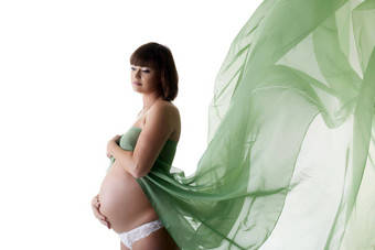 美丽的怀孕了女人绿色吹织物