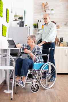 禁用高级女人轮椅平板电脑电脑厨房