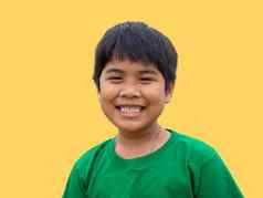 男孩穿绿色衬衫站在微笑黄色的背景