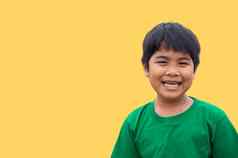 男孩穿绿色衬衫站在微笑黄色的背景