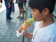 男孩穿白色衬衫吃冰奶油
