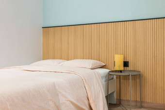 双床上枕头使大温暖的羽绒被床单愉快的米色颜色表格灯黄色的框架软温暖的光晚上现代设计墙木镶板