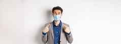科维德流感大流行业务概念兴奋商人西装指出医疗面具相机白色背景