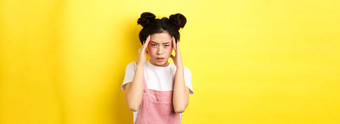 图像时尚的日本女人明亮的化妆头疼触<strong>碰头</strong>累了痛苦的偏头痛黄色的背景