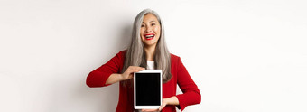 业务快乐的亚洲女商人红色的夹克显示数字平板电脑屏幕微笑介绍应用程序促销活动白色背景