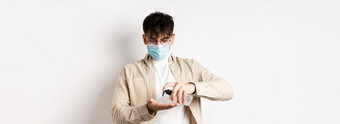 健康科维德检疫概念年轻的拉美裔的家伙眼镜脸面具手洗手液应用防腐剂站白色背景
