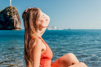 年轻的女人红色的比基尼海滩女孩说谎卵石海滩享受太阳快乐夫人长头发洗澡西装令人心寒的日光浴绿松石海海洋热夏天一天关闭