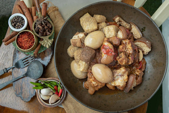 红烧猪肉腿煮熟的鸡蛋豆腐陶瓷碗服务大蒜guinea-peppers木背景